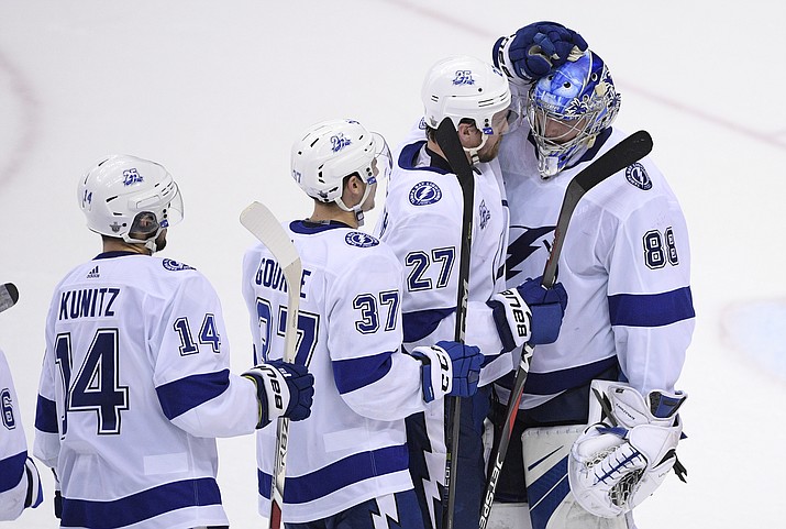 Tampa Bay Lightning's Andrei Vasilevskiy (88), of Russia, celebrates with Ryan McDonagh (27), Yanni Gourde (37) and Chris Kunitz (14) after Game 3 of the team's NHL Eastern Conference finals hockey playoff series against the Washington Capitals, Tuesday, May 15, 2018 in Washington. The Lightning won 4-2. (AP Photo/Nick Wass)