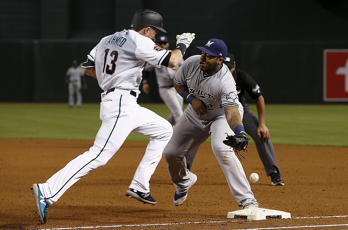Arizona Diamondbacks’ Nick Ahmed (13) reaches first base on a throwing error by Milwaukee Brewers pitcher Jhoulys Chacin as Brewers first baseman Jesus Aguilar is unable to make the catch during the fifth inning of a baseball game Tuesday, May 15, 2018, in Phoenix. (AP Photo/Ross D. Franklin)