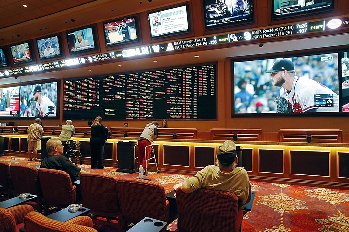 In this May 14 photo, people make bets in a sports book in Las Vegas. Now that the U.S. Supreme Court has cleared the way for states to legalize sports betting, the race is on to see who will referee the multi-billion-dollar business expected to emerge.  (John Locher/AP)