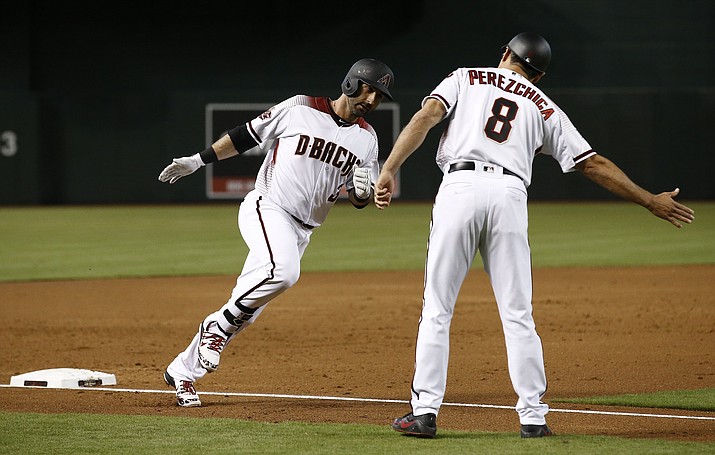 Arizona Diamondbacks’ Daniel Descalso, left, gets ready to slap hands with third base coach Tony Perezchica (8) after Descalso’s two-run home run against the Milwaukee Brewers in the first inning of a baseball game Wednesday, May 16, 2018, in Phoenix. (AP Photo/Ross D. Franklin)