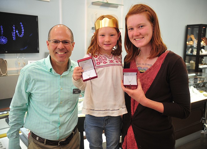 Greg Raskin, of Raskin's Jewelers, presents Ivy and Amanda Hermance -- the winners of The Daily Courier’s 2018 Mother/Daughter Look-alike Contest -- with pendants Wednesday, May 16, 2018 in Prescott. (Les Stukenberg/Courier)