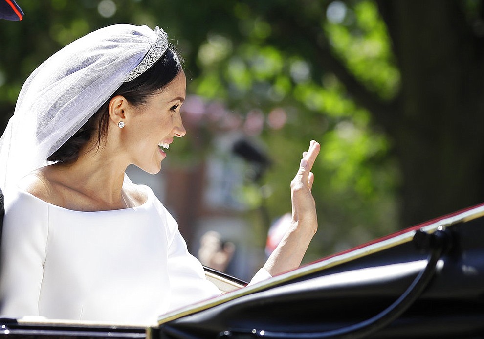 Meghan Markle waves from a carriage after the wedding ceremony of Prince Harry and Meghan Markle at St. George's Chapel in Windsor Castle in Windsor, near London, England, Saturday, May 19, 2018. (AP Photo/Kirsty Wigglesworth, pool)