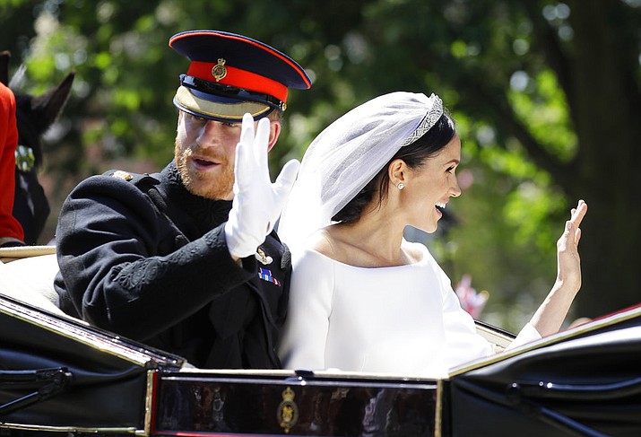 Britain's Prince Harry, left, and Meghan Markle wave from a carriage after their wedding ceremony at St. George's Chapel in Windsor Castle in Windsor, near London, England, Saturday, May 19, 2018. (AP Photo/Kirsty Wigglesworth, pool)