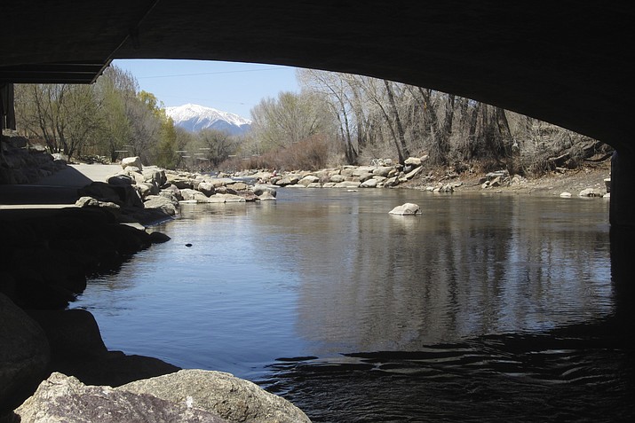 In this April 25, 2018 photo, the Arkansas River flows under a bridge in Salida, Colo., with the snow-covered Sawatch Range mountains in the background. Despite a severe drought across the Southwestern United States, there should be plenty of water this year for rafters and anglers in the Arkansas, one of the nation's most popular mountain rivers. State and federal officials say water from melting snow will surge down the river thanks to a surprisingly wet winter in the towering peaks of the Sawatch Range where the river begins. (AP Photo/Dan Elliott)

