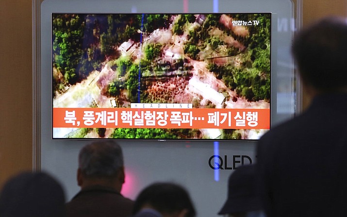 People watch a TV screen showing a satellite image of the Punggye-ri nuclear test site in North Korea during a news program at the Seoul Railway Station in Seoul, South Korea, Thursday, May 24, 2018. North Korea carried out what it said is the demolition of its nuclear test site Thursday, setting off a series of explosions over several hours in the presence of foreign journalists.The signs read: " North Korea demolishes nuclear test site." (AP Photo/Ahn Young-joon)