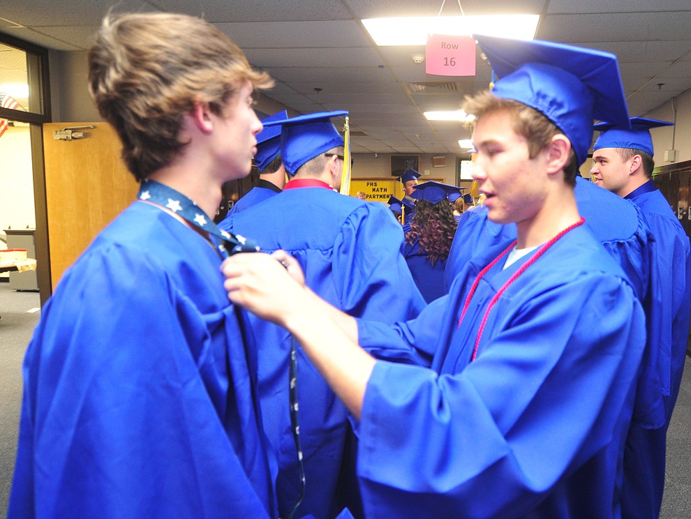 Aaron Martin gets help with his tie from Wyatt Harness before the 2018 Prescott High School Commencement Ceremony at the school Friday, May 25, 2018. (Les Stukenberg/Courier)