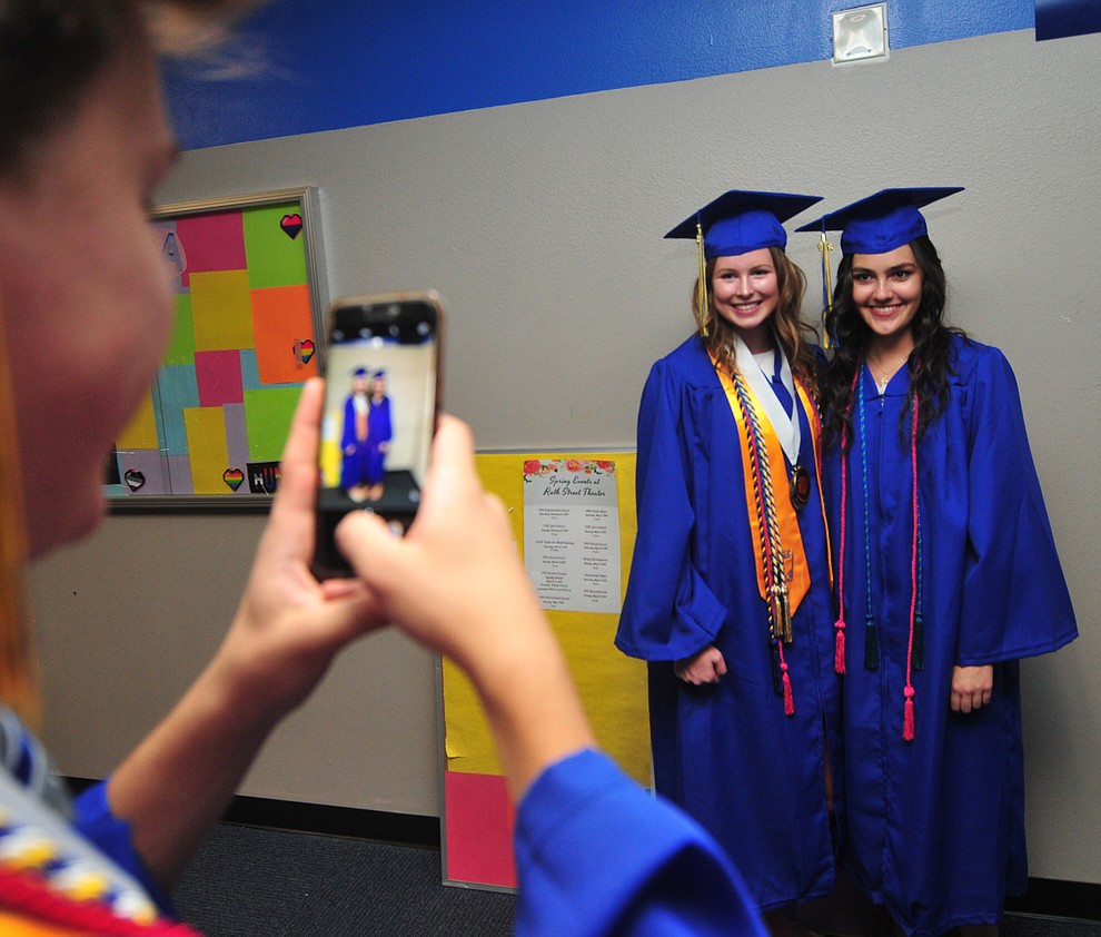 Wesley Bradstreet takes a photo of Lexis Hammes and Mary Powers before the 2018 Prescott High School Commencement Ceremony at the school Friday, May 25, 2018. (Les Stukenberg/Courier)
