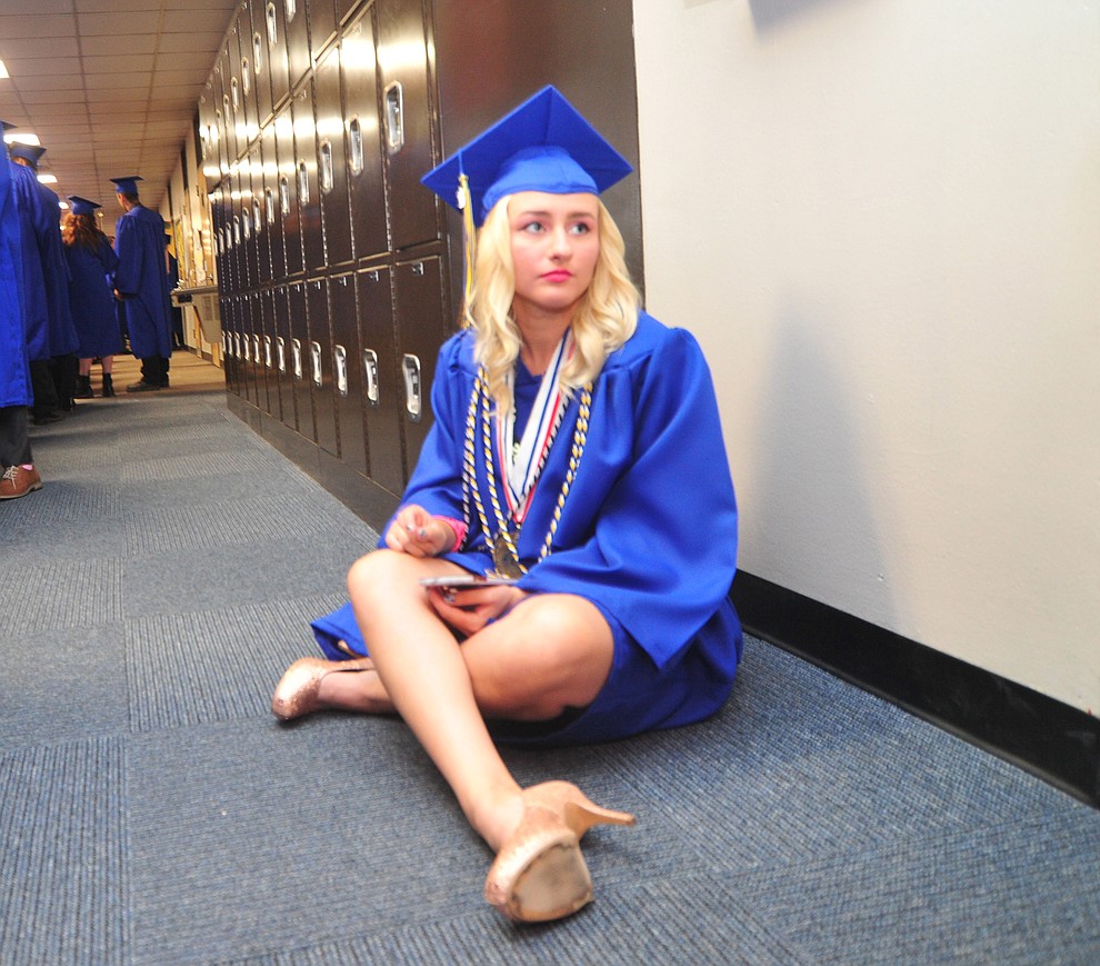 Amanda Hugeri takes a break in the hallway before the 2018 Prescott High School Commencement Ceremony at the school Friday, May 25, 2018. (Les Stukenberg/Courier)