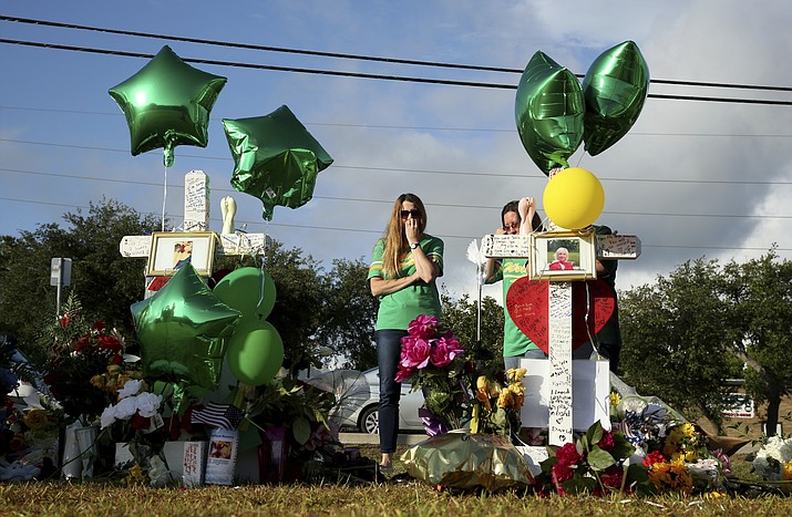 Women visit a memorial for the Santa Fe High School shooting victims outside the school Wednesday, May 23, 2018, in Santa Fe, Texas. (Godofredo A. Vasquez /Houston Chronicle via AP)

