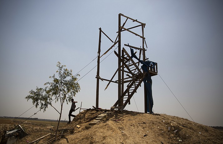 A Palestinian man inspects a military observation post that was hit by an Israeli tank shell in Khan Younis, southern Gaza Strip, Sunday, May 27, 2018. Palestinian officials said an Israeli strike killed two Gaza militants, after Israel's military said it targeted a militant observation post in response to an explosive device placed along the border. (AP Photo/Khalil Hamra)

