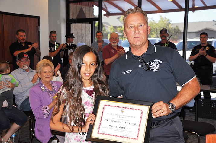 Central Arizona Fire and Medical Authority (CAFMA) Fire Marshall Rick Chase presents a certificate of appreciation to 9-year-old Mariana Schubert at CAFMA’s fire board meeting on Thursday, May 24. She played a major role in a recent emergency incident by bringing it to the attention of adults. (Bill Brookins/Courtesy)
