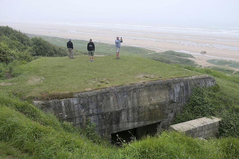 US Tourists have a look at Omaha beach next to the Colleville American military cemetery, in Colleville sur Mer, western France, Wednesday June 6, 2018, on the 74th anniversary of the D-Day landing. U.S. and other allied troops have joined veterans of the D-Day invasion and families of fallen soldiers to mark 74 years since the massive military operation that change the course of World War II. (AP Photo/David Vincent)