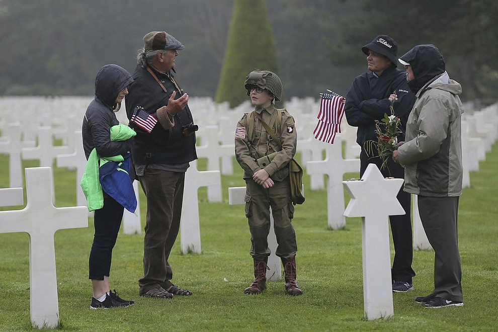 David Chamberlain, second right and his family, from left to right, his wife June, his son Steve, center, and grandfather Charly Powers, from Atlanta, Georgia, visit the Colleville American military cemetery, in Colleville sur Mer, western France, Wednesday June 6, 2018, on the 74th anniversary of the D-Day landing. U.S. and other allied troops have joined veterans of the D-Day invasion and families of fallen soldiers to mark 74 years since the massive military operation that change the course of World War II. (AP Photo/David Vincent)