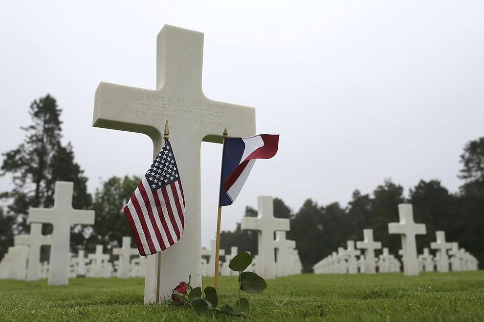 US and French flags and a flower are placed on the grave ofJames D. Black, from New York, who died on June 11, 1944, at the Colleville American military cemetery, in Colleville sur Mer, western France, Wednesday June 6, 2018, on the 74th anniversary of the D-Day landing. (AP Photo/David Vincent)