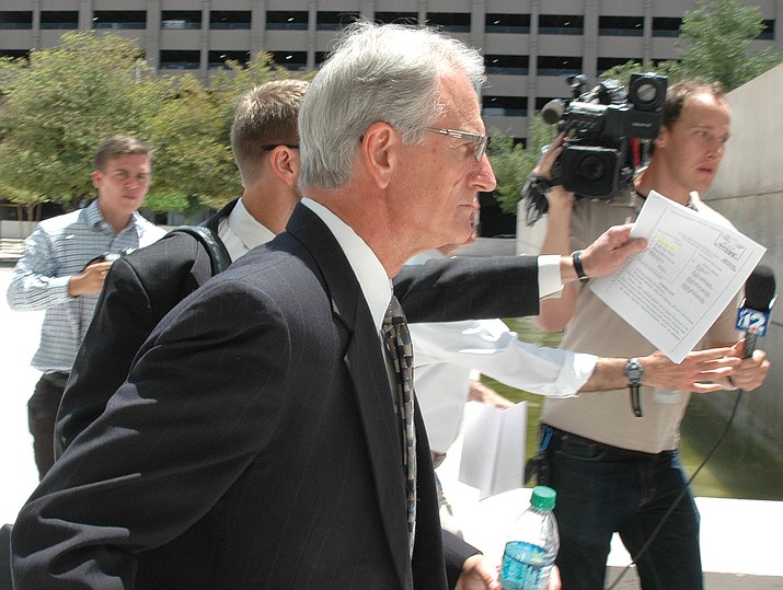 Former utility regulator Gary Pierce rushes past reporters last year following his initial court appearance. Howard Fischer/Courtesy)