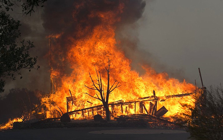 In this Oct. 9, 2017 file photo, flames from a wildfire consume a home, near Napa, Calif. Downed power lines caused a dozen Northern California wildfires last fall, including two that killed a total of 15 people, California's Department of Forestry and Fire Protection said Friday, June 8, 2018. The wildfires were part of a series that were the deadliest in California history. (AP Photo/Rich Pedroncelli, file)

