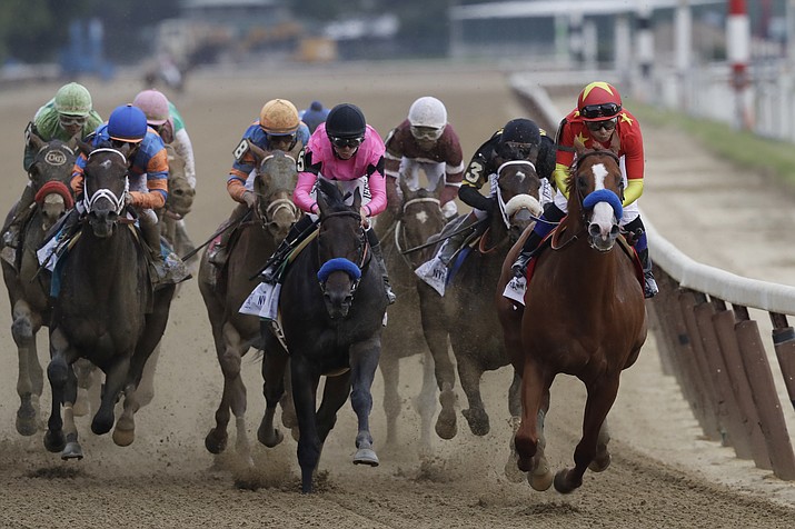 Justify, right, ridden Mike Smith leads the field at the end of the backstretch during the Belmont Stakes horse race, Saturday, June 9, 2018, at Belmont Park in Elmont, N.Y. Justify won the race, to claim horse racing's Triple Crown. (Mark Lennihan/AP)