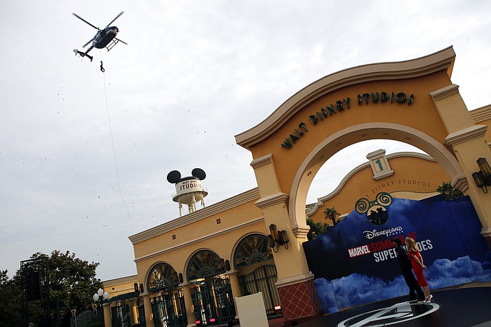 A swat character performs from an helicopter during the opening show at Disneyland Paris, west of Paris, Saturday, June 8, 2018. Helicopters, concept cars and swat teams shrouded in smoke heralded the launch of the first Avengers-themed season at Disneyland Paris following the announcement of a $2.5 billion expansion plan for the park, which will feature Marvel superheroes. (AP Photo/Francois Mori)

