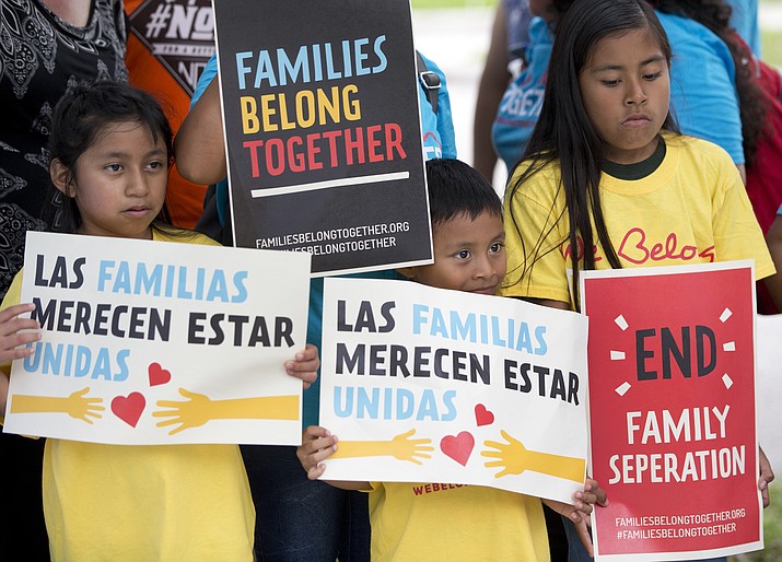 In this June 1, 2018, file photo, children hold signs during a demonstration in front of the Immigration and Customs Enforcement offices in Miramar, Fla. The Trump administration's move to separate immigrant parents from their children on the U.S.-Mexico border has turned into a full-blown crisis in recent weeks, drawing denunciation from the United Nations, Roman Catholic bishops and countless humanitarian groups. (AP Photo/Wilfredo Lee, File)

