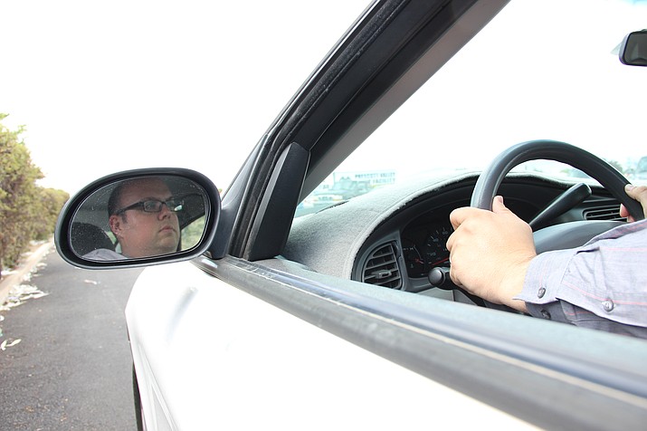 Jon Wittenberg sits in a white 2003 Ford Taurus, the same vehicle he was in when troopers with the Arizona Department of Public Safety mistakenly believed him to be a suspect involved in an attempted murder on Tuesday, June 12, in the Prescott Valley area. (Max Efrein/Courier)