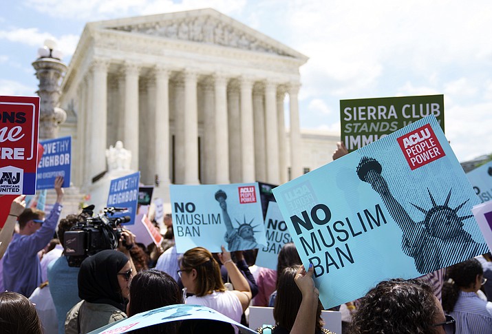 Protesters hold up signs and call out against the Supreme Court ruling upholding President Donald Trump's travel ban outside the the Supreme Court in Washington, Tuesday, June 26, 2018. (AP Photo/Carolyn Kaster)


