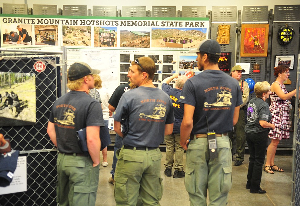Crew members from Engine 611 from the Black Hills National Forest North Zone look at the displays as the Granite Mountain Interagency Hotshot Crew Learning and Tribute Center opens at the  Prescott Gateway Mall Friday, June 29, 2018.(Les Stukenberg/Courier)