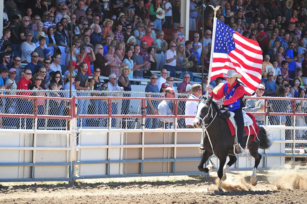 Sami Kilduff brings in the American Flag during third performance of the Prescott Frontier Days Rodeo Saturday, June 30, 2018.(Les Stukenberg/Courier)
