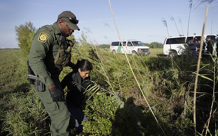 In this Aug. 11, 2017 file photo a U.S. Customs and Border Patrol agent escorts an immigrant suspected of crossing into the United States illegally along the Rio Grande near Granjeno, Texas. A U.S. official tells The Associated Press that Border Patrol arrests fell sharply in June 2018 to the lowest level since February, ending a streak of four straight monthly increases. The drop may reflect seasonal trends or it could signal that President Donald Trump's "zero-tolerance" policy to criminally prosecute every adult who enters the country illegally is having a deterrent effect. The official spoke on condition of anonymity because the numbers are not yet intended for public release. (AP Photo/Eric Gay, File)

