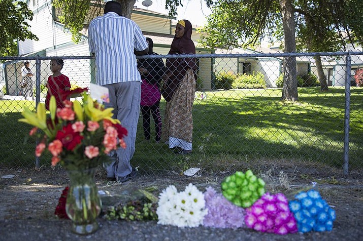Ibod Hasn, center, talks to a friend who came to visit after Saturday's stabbing attack in Boise, Idaho, Sunday, July 1, 2018. A man who had been asked to leave an Idaho apartment complex because of bad behavior returned the next day and stabbed people, including several children, at a toddler's birthday party, police said. (Meiying Wu/Idaho Statesman via AP)

