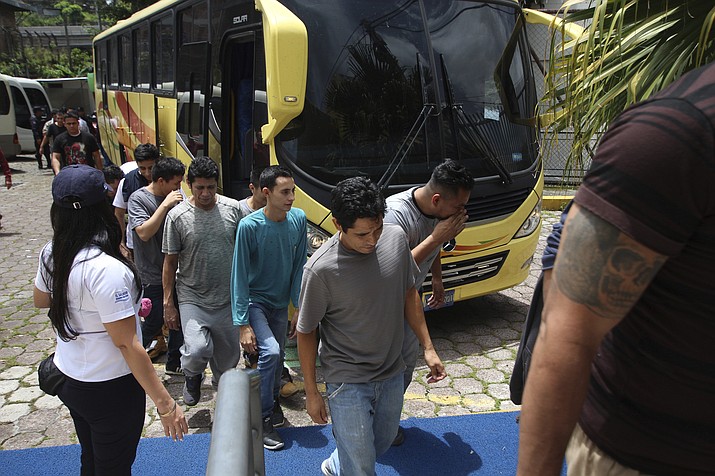 In this June 28, 2018 photo, a group of Salvadoran deportees arrive at La Chacra Immigration Center in San Salvador, El Salvador. La Chacra, the neighborhood or "colonia" where the immigration center sits behind high stone walls, is controlled by Mara Salvatrucha gang. (AP Photo/Salvador Melendez)


