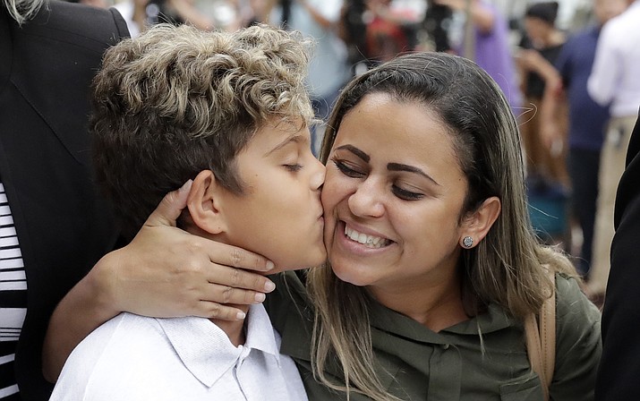 Diego Magalhaes, left, 10, kisses his mother Sirley Silveira, Paixao, an immigrant from Brazil seeking asylum with her son, after Diego was released from immigration detention, Thursday, July 5, 2018, in Chicago. (AP Photo/Charles Rex Arbogast)

