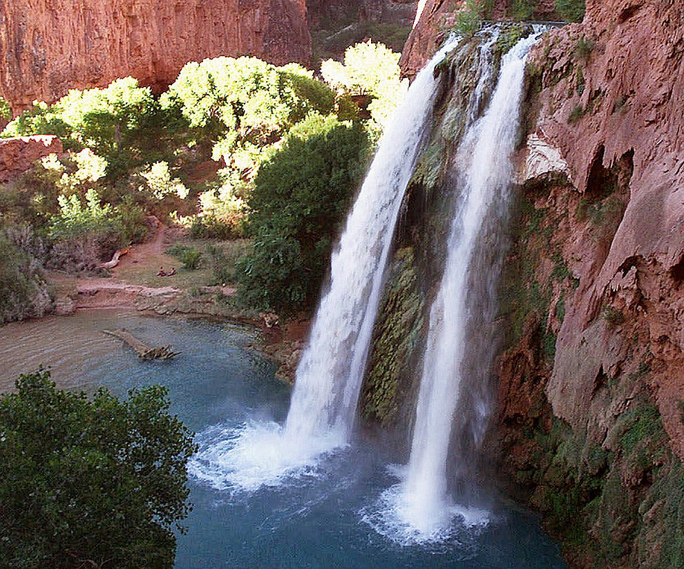 FILE - This 1997 file photo shows one of five waterfalls on Havasu Creek as its waters tumble 210 feet on the Havasupai Tribe's reservation in a southeastern branch of the Grand Canyon near Supai, Ariz. About 200 tourists are being evacuated from a campground on tribal land near famous waterfalls deep in a gorge off the Grand Canyon. Officials with the Havasupai Tribe say their reservation was hit with two rounds of flooding Wednesday, July 11, 2018, and early Thursday. (AP Photo/Bob Daugherty, File)