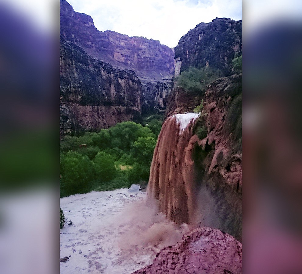 This Wednesday, July 11, 2018 photo released by Benji Xie shows flooding from a waterfall on the Havasupai reservation in Supai, Ariz. About 200 tourists were evacuated July 12 from a campground on tribal land near famous waterfalls deep in a gorge off the Grand Canyon. (Benji Xie via AP)
