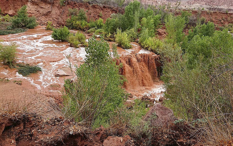 This Thursday, July 12, 2018 photo released by Benji Xie shows flooding from a waterfall on the Havasupai reservation in Supai, Ariz. About 200 tourists were evacuated July 12 from a campground on tribal land near famous waterfalls deep in a gorge off the Grand Canyon. (Benji Xie via AP)