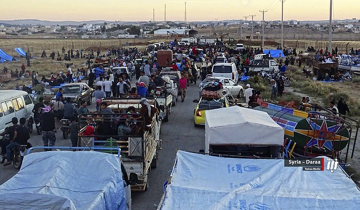 This June 30, 2018 file photo provided by Nabaa Media, a Syrian opposition media outlet, shows people in their vehicles who fled from Daraa, gathering near the Syria-Jordan border. Syrian activists and state media said Thursday, July 12, 2018 that the rebels have agreed to surrender Daraa, the first city to revolt against President Bashar Assad with Arab Spring-inspired protests seven years ago, to government forces. (Nabaa Media, via AP, File)


