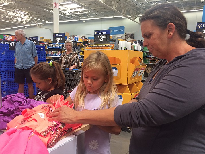 Riley Lopez, Claire Andringa and Maryann Andringa take a look at some clothes at the Prescott Valley Walmart Saturday, July 14. (Jason Wheeler/Courier)