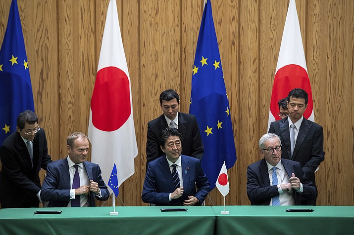 Japanese Prime Minister Shinzo Abe, center, signs a contract with European Union’s Commission President Jean-Claude Juncker, right, and European Union’s Council President Donald Tusk Tuesday, July 17, 2018, at the prime minister’s office in Tokyo. (Martin Bureau/Pool Photo via AP)