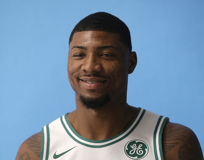 In this Sept. 25, 2017, file photo, Boston Celtics' Marcus Smart poses during NBA basketball media day, in Canton, Mass. The Celtics have re-signed guard Marcus Smart. A person with knowledge of the agreement tells The Associated Press that Smart signed a four-year, $52 million contract with the Celtics. The person spoke to the AP on condition of anonymity Thursday, July 19, 2018, because the team did not disclose the terms of the contract. (Steven Senne/AP, File)