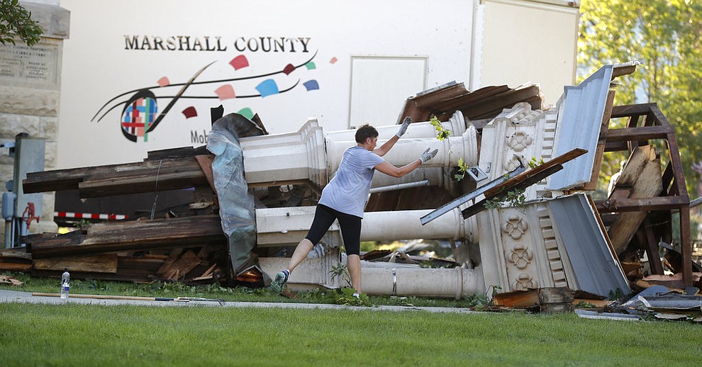 A worker cleans up debris from the tornado damaged Marshall County Courthouse's tower Thursday, July 19, 2018, in Marshalltown, Iowa. Several buildings were damaged by a tornado in the main business district in town including the historic courthouse. (AP Photo/Charlie Neibergall)