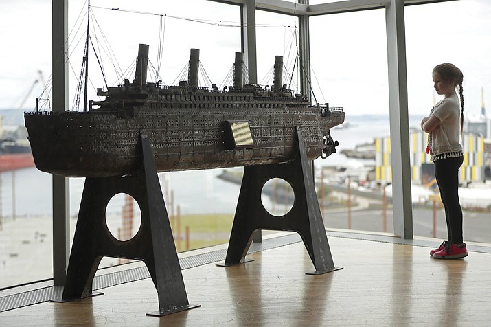 Aoise Taggert, aged nine, looks at a model of the Titanic at Titanic Belfast, Northern Ireland, Tuesday July 24, 2018, during the launch of a bid to buy a collection of 5,500 artifacts from the Titanic wreck site and bring them to Belfast. A group of British museums will raise money to buy the Titanic artifacts from the private American company that salvaged them from the wreck of the passenger liner RMS Titanic. (Niall Carson/PA Wire(/PA via AP)