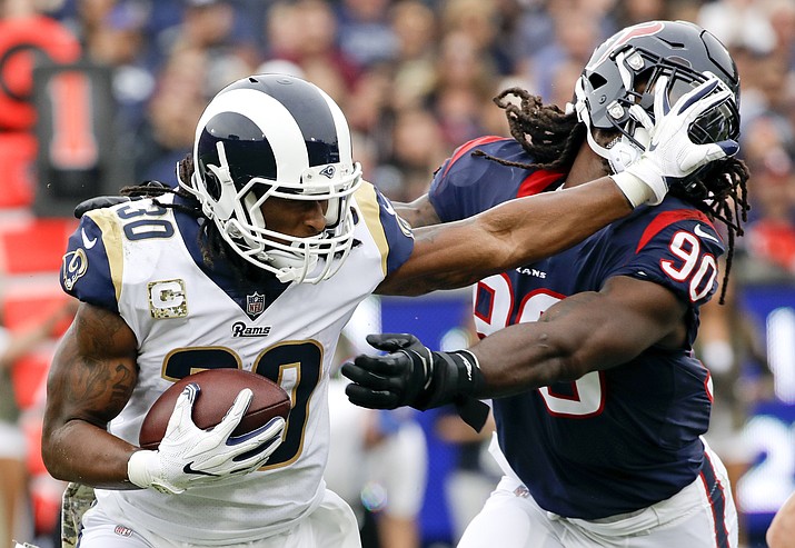 In this Nov. 12, 2017, file photo, Los Angeles Rams running back Todd Gurley pushes away Houston Texans outside linebacker Jadeveon Clowney during the first half of an NFL football game, in Los Angeles. Gurley has agreed to a lucrative contract extension with the Rams on a four-year extension worth $60 million through 2023. (Alex Gallardo/AP, file)