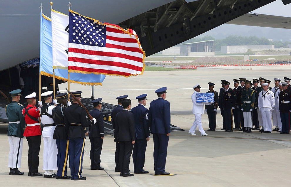 A U.N. honor guard carries a casket containing remains believed to be from American servicemen killed during the 1950-53 Korean War after arriving from North Korea, at Osan Air Base in Pyeongtaek, South Korea, Friday, July 27, 2018. The U.N. Command says the 55 cases of war remains retrieved from North Korea will be honored at a ceremony next Wednesday at a base in South Korea. (AP Photo/Ahn Young-joon, Pool)
