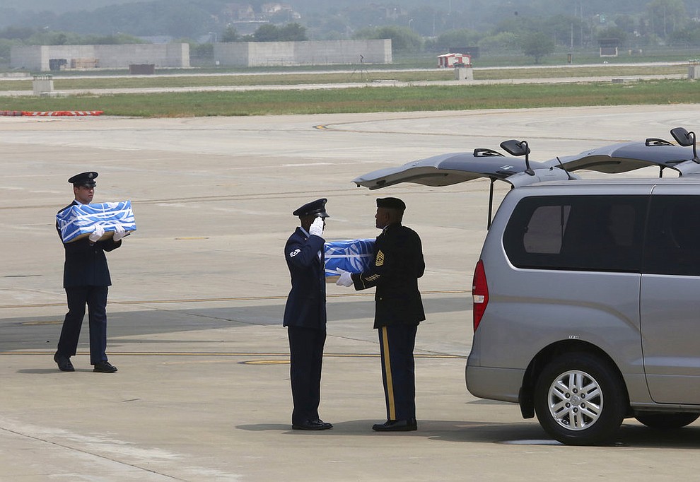 A U.N. honor guard salutes after turning over a box containing remains believed to be from American servicemen killed during the 1950-53 Korean War, to his fellow after arriving from North Korea, at Osan Air Base in Pyeongtaek, South Korea, Friday, July 27, 2018. The U.N. Command says the 55 cases of war remains retrieved from North Korea will be honored at a ceremony next Wednesday at a base in South Korea. (AP Photo/Ahn Young-joon. Pool)