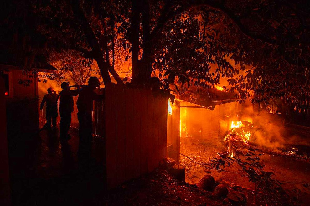 Firefighters work to battle the Carr Fire at a home in Redding, Calif., Thursday, July 26, 2018. (Daniel Kim/The Sacramento Bee via AP)