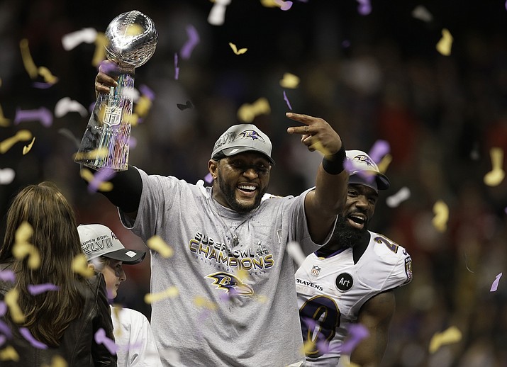 In this Feb. 3, 2013, file photo, Baltimore Ravens linebacker Ray Lewis holds up the Vince Lombardi Trophy as he celebrates with free safety Ed Reed (20) after the Ravens defeated the San Francisco 49ers 34-31 in the NFL football Super Bowl 47 in New Orleans. Lewis and Brian Urlacher, two of the NFL's greatest linebackers, enter the Pro Football Hall of Fame this week. When their teams meet in the preseason opener, Thursday, Aug. 2, 2018 the game could very well honor them by being a defensive battle. (Elaine Thompson/AP, file)