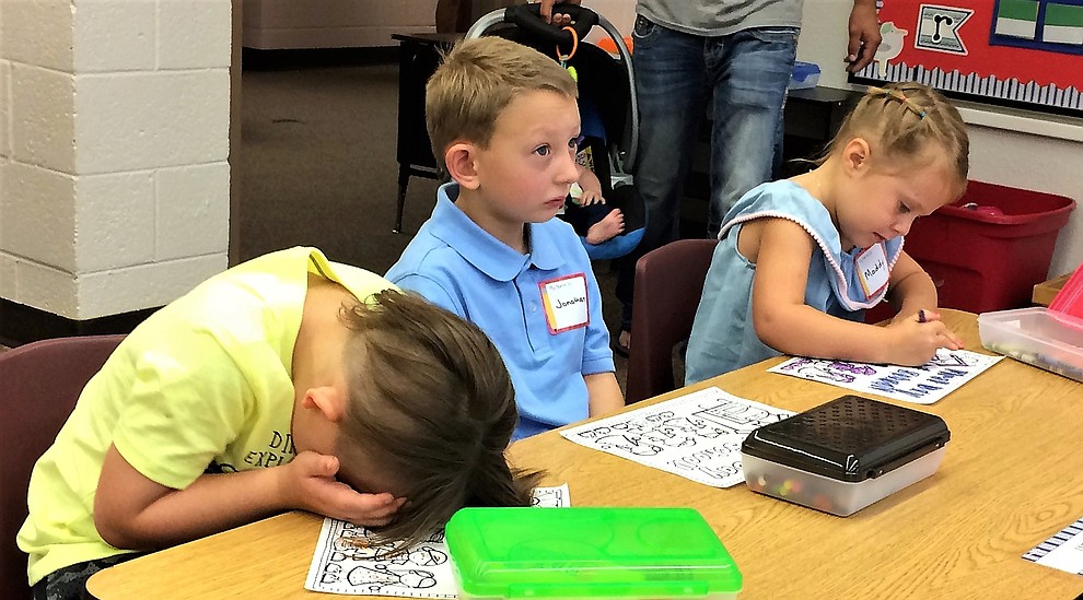 Some new kindergartners busied themselves with coloring, while others appear a little lost on the first day of school Monday, Aug. 6, at Mountain View Elementary School in Prescott Valley. From left are Erik Theodoroff, Jonathan Casteel and Maddy Parks. (Sue Tone/Courier)
