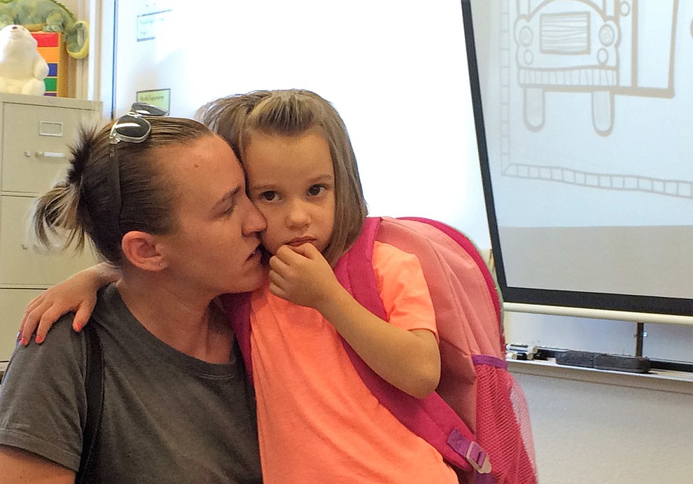 Looking a little apprehensive, new kindergarten student Kyra Boals is comforted by her mother, Jami Dowog, on the first day of school Monday, Aug. 6, at Mountain View Elementary School in Prescott Valley. (Sue Tone/Courier)