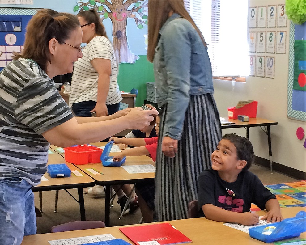 Kindergartner Amarii McGhee flashes a big smile as his grandmother, Alicia Neal, takes a photo on the first day of school Monday, Aug. 6, at Mountain View Elementary School in Prescott Valley. (Sue Tone/Courier).