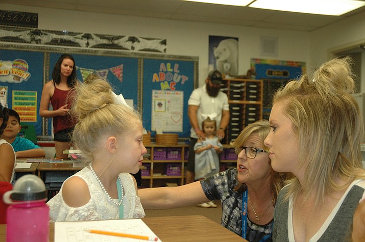Del Rio Elementary School third grade teacher Robin Bond and Lacee Fletcher help Fletcher’s daughter Emma Fletcher get settled for her first day of third grade. (Jason Wheeler/Review)