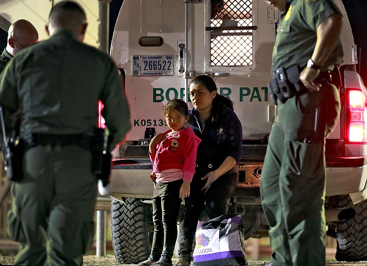 A mother and 5-year-old daughter from Honduras are detained by U.S. Customs and Border Patrol agents Wednesday, July 18, 2018, in San Luis, Ariz. The pair were apprehended by a U.S. Border Patrol agent who spotted them crossing a canal along the border with Mexico. (Matt York/AP)